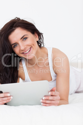 Happy brunette woman using her tablet computer