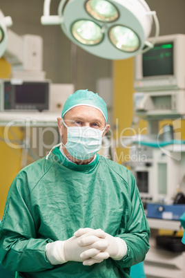 Surgeon smiling while crossing his hands