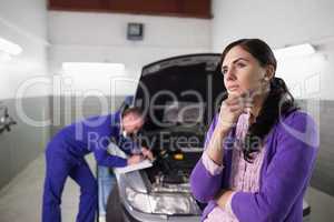 Thoughtful woman next to a car