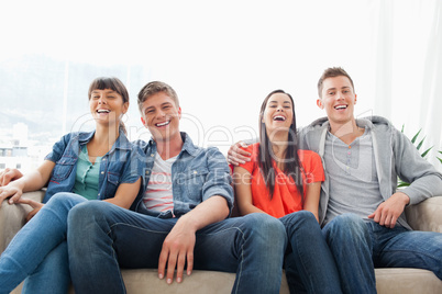 A group of laughing friends look into the camera