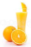 One orange and a half next to a glass of orange juice