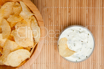 A bowl of chips and a bowl of dip side by side