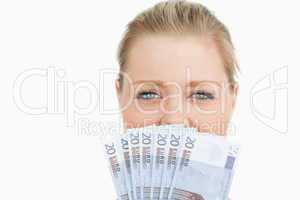 Woman hiding her mouse with her euros banknotes