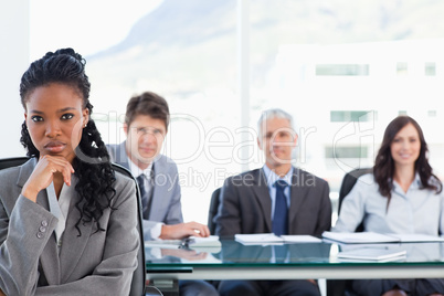 Businesswoman sitting with her hand on her chin in front of her
