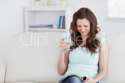 Woman reading a magazine while sitting on a sofa