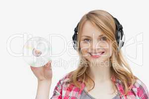 Woman holding a cd while wearing headphones