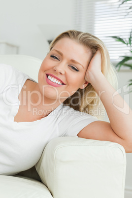 Woman lying on a sofa with a hand in her hair