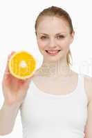 Woman holding an orange while smiling