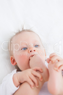 Cute baby placing her foot on her mouth