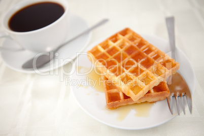 Waffles placed near a coffee cup