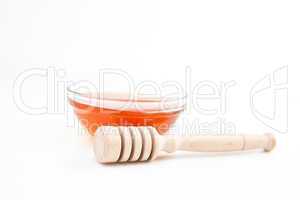 Honey bowl behind a honey dipper