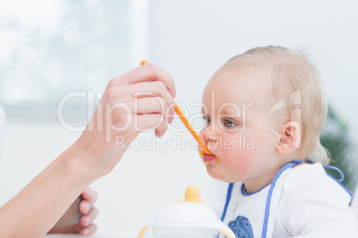 Baby with a plastic spoon on his mouth