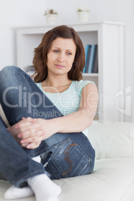Woman sitting on a sofa thinking
