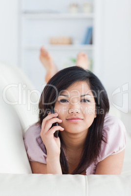 Woman phoning while lying on a couch