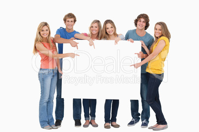 Smiling group of people with a blank space as they point to it