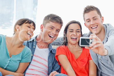 A laughing group pose for a photo in front of them