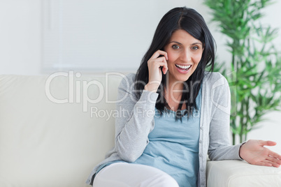 Woman talking on the phone while resting on a couch