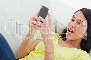 Close-up of a surprised Latino looking her smartphone