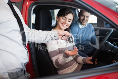 Salesman giving keys to a smiling couple