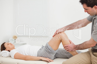 Woman lying while a man manipulating her leg