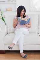 Woman reading a book while sitting on a couch