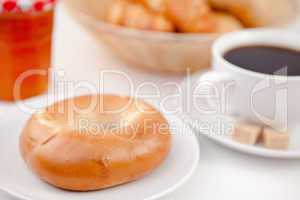 Doughnut and a cup of coffee on white plates with sugar and milk