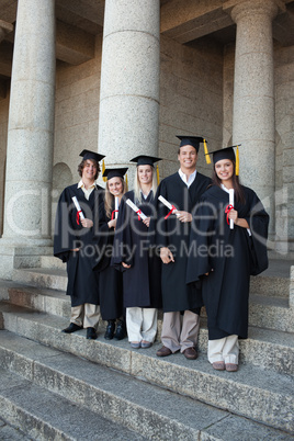 Laughing graduates posing the thumb-up