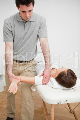 Serious practitioner holding the arm of a woman