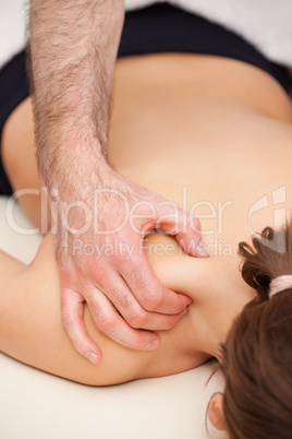 Doctor squeezing the top of the back of his patient