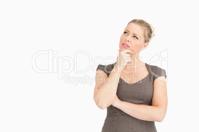 Woman thinking with a finger on her face