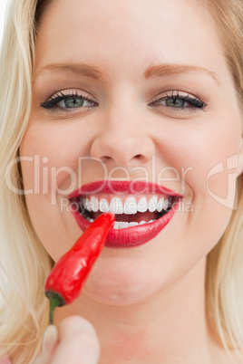 Happy blonde woman eating a chili
