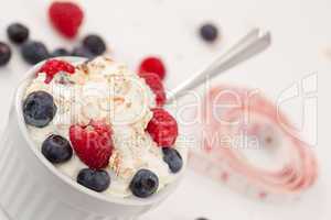 Tape measure and a jar of fruits with whipped cream