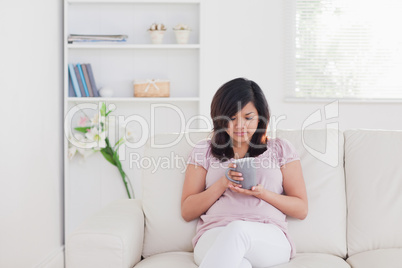 Woman relaxing as she sits on a sofa