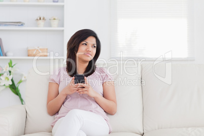 Woman sitting on a sofa and holding a phone