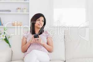 Woman sitting on a sofa and holding a phone