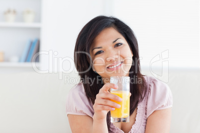 Smiling woman holding a glass of orange juice