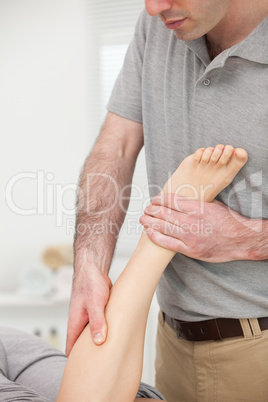 Doctor massaging the leg of a woman while she is lying