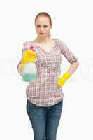 Serious woman holding a spray bottle while standing