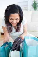 Woman taking clothes off from a shopping bag