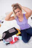 Blonde having problem to close her suitcase