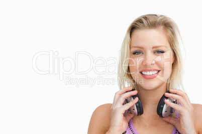 Peaceful blonde woman holding her headphones