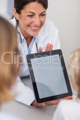 Smiling doctor presenting a tablet computer