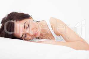Brunette woman falling asleep in her bed