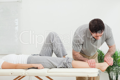 Chiropractor examining the foot of a woman