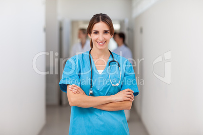 Smiling nurse folding her arms while standing