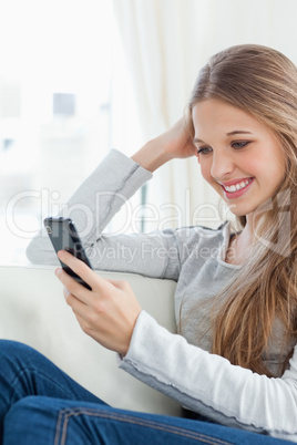 Smiling girl with her mobile phone as she checks her messages