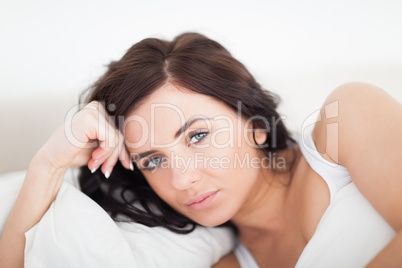 Serious woman lying on her bed