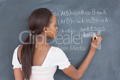 Black student writing on a blackboard