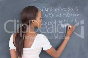 Black student writing on a blackboard