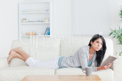 Woman relaxing on a couch while holding a book